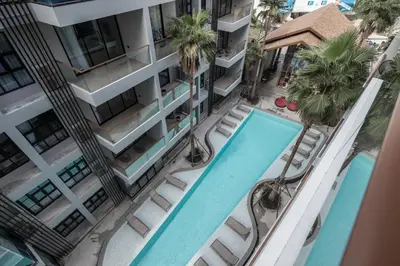 an overhead view of a building with two pools and palm trees at Palmyrah Surin Beach Residence in Surin Beach