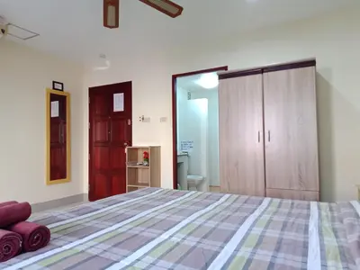 a bedroom with a large bed and a closet at Living Room Guesthouse & Cafe Bar in Karon Beach