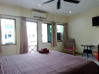 a bedroom with a bed with a stuffed animal on it at Living Room Guesthouse & Cafe Bar in Karon Beach