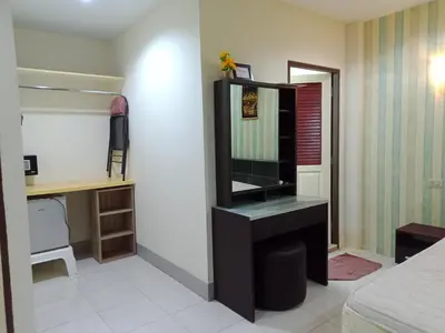 a bedroom with a mirror and a tv on a desk at Living Room Guesthouse & Cafe Bar in Karon Beach