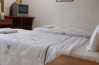 two beds sitting next to each other in a room at Praew Mansion in Kamala Beach
