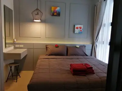 a bedroom with a bed with a red bag on it at Palmyrah Surin Beach By Risa in Surin Beach