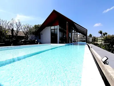 a large swimming pool with a building in the background at Palmyrah Surin Beach By Risa in Surin Beach