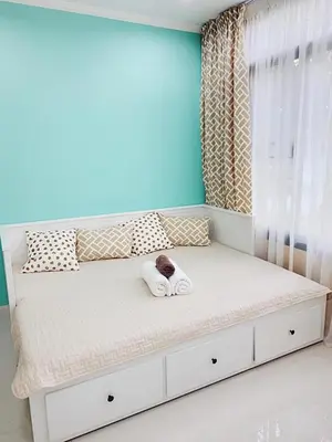 a white bed in a room with a window at The Kamala Regent by My Home Phuket in Kamala Beach