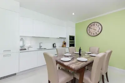 a dining room with a table and a clock on the wall at The Kamala Regent by My Home Phuket in Kamala Beach
