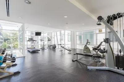 a gym with several treadmills and machines in a room at The Kamala Regent by My Home Phuket in Kamala Beach