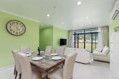 a dining room with a table and a clock on the wall at The Kamala Regent by My Home Phuket in Kamala Beach