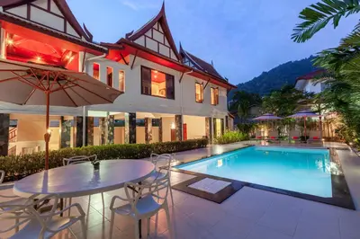 a house with a swimming pool and a table and chairs at Sabai Villa Kata by RESAVA in Kata Beach