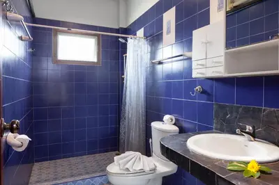 a blue tiled bathroom with a toilet and a sink at Sabai Villa Kata by RESAVA in Kata Beach