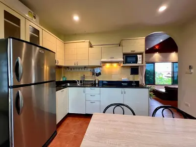 a large kitchen with a stainless steel refrigerator at Sabai Villa Kata by RESAVA in Kata Beach