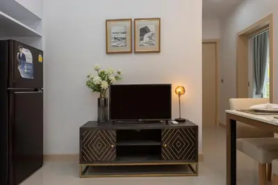 a living room with a tv on a wooden stand at Palmetto by Holy Cow, 2-BR, jungle view in Karon Beach