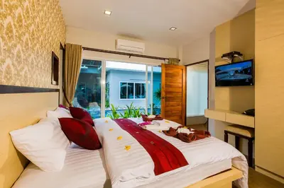 a bedroom with a large white bed with red pillows at Irawan House in Ao Nang Beach