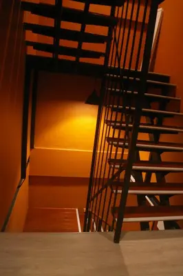 a spiral staircase in a room with an orange wall at Aonang Inn in Krabi town
