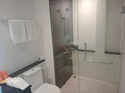 a bathroom with a shower with a toilet and a glass door at Aonang Inn in Krabi town