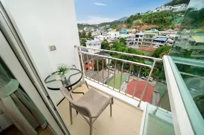 a balcony with a glass table and chair and a view at Ozone Kata -Great location, rooftop pool, convenient studio in Karon Beach