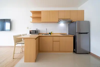 a kitchen with a refrigerator and a table at Ozone Kata -Great location, rooftop pool, convenient studio in Karon Beach