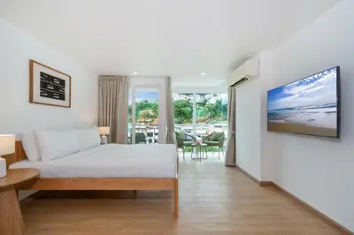 a living room with a bed and a tv at Ozone Kata -Great location, rooftop pool, convenient studio in Karon Beach