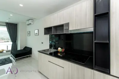 a kitchen with black appliances and a black counter top at Luxury Lagoon 1bedroom Apartment in Kamala Beach