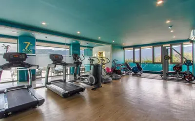 a gym with several treadmills and elliptical machines at Luxury Lagoon 1bedroom Apartment in Kamala Beach