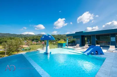 a swimming pool with an umbrella in the middle of a house at Luxury Lagoon 1bedroom Apartment in Kamala Beach