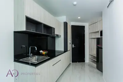 a kitchen with a sink and a black refrigerator at Luxury Lagoon 1bedroom Apartment in Kamala Beach