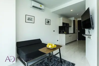 a living room with a couch and a bowl of fruit on a table at Luxury Lagoon 1bedroom Apartment in Kamala Beach