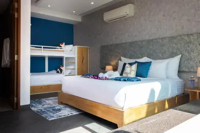 a bedroom with a large white bed and bunk beds at Villa Beyond-Namaste 16 Bedroom Fully Staffed Seaview Villa in Ban Thalat Choeng Thale
