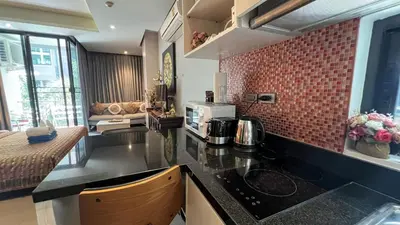 a kitchen with a black counter top and red brick wall at Relife Windy by Nataly in Phuket Town