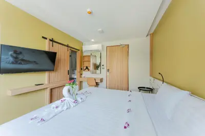 a bedroom with a white bed with flowers on it at Sky Wave Patong in Patong Beach