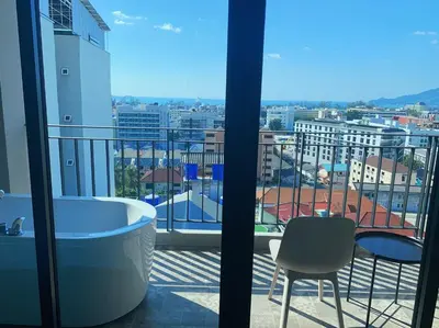 a bathroom with a tub and a view of a city at Sky Wave Patong in Patong Beach