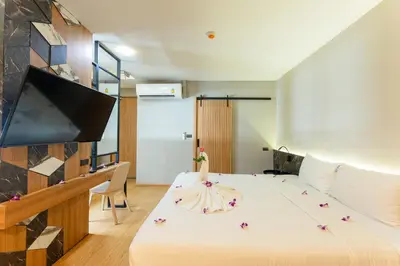 a bedroom with a large bed and a flat screen tv at Sky Wave Patong in Patong Beach