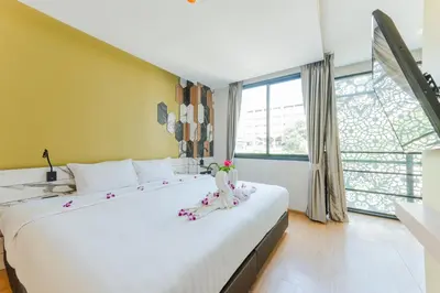a large white bed in a room with a large window at Sky Wave Patong in Patong Beach