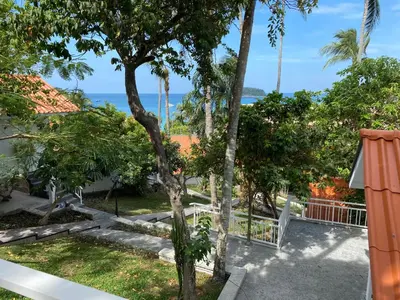 a view of the ocean from the balcony of a house at Kata White Villas in Kata Beach