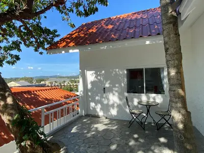 a balcony of a white house with a table and chairs at Kata White Villas in Kata Beach