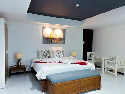a bedroom with a large bed and a table at The Sands 3 Bedrooms Beachside Apartment in Naiharn in Nai Harn Beach