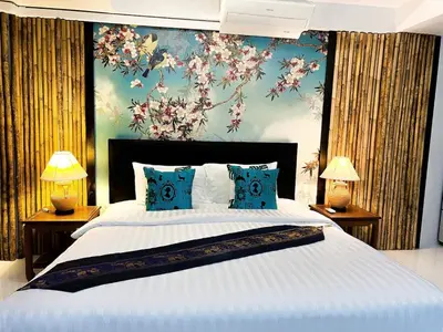 a bedroom with a large white bed with blue pillows at The Sands 3 Bedrooms Beachside Apartment in Naiharn in Nai Harn Beach