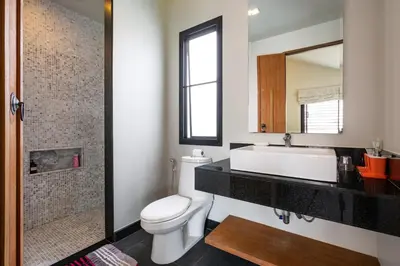 a bathroom with a toilet and a sink and a mirror at Beautiful 3 bedroom pool villa with 65inch smart tv Located near popular Bangtao beach and laguna Phuket in Bang Tao Beach
