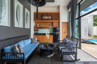 a living room with a blue couch and chairs at Beautiful 3 bedroom pool villa with 65inch smart tv Located near popular Bangtao beach and laguna Phuket in Bang Tao Beach