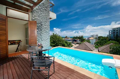 a patio with a table and chairs next to a swimming pool at Prima Villas Karon Phuket in Karon Beach