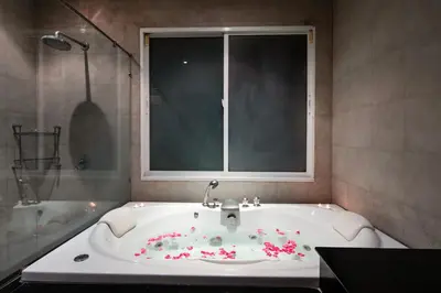 a bathroom with a tub with flowers on it at Prima Villas Karon Phuket in Karon Beach