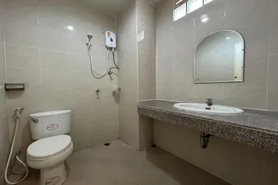 a bathroom with a toilet and a sink and a mirror at SB Park Mansion in Phuket Town