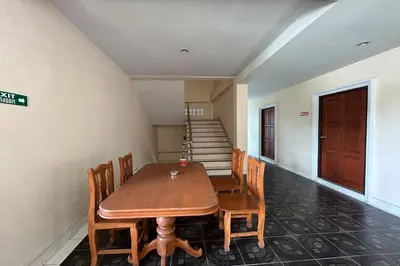 a dining room with a table and chairs and stairs at SB Park Mansion in Phuket Town