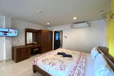 a bedroom with a bed and a flat screen tv at SB Park Mansion in Phuket Town