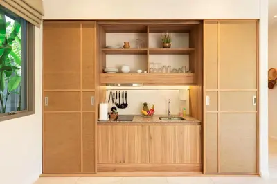 a kitchen with wooden cabinets and a sink at Modern Pool Villa Dalaa 7 in Kamala Beach