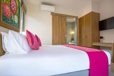 a bedroom with a large white bed with pink pillows at Modern Pool Villa Dalaa 7 in Kamala Beach