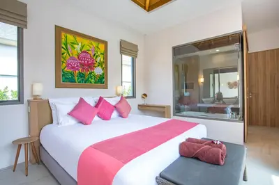 a bedroom with a large bed and a bathroom at Beach escape at Villa Dalaa 8 in Kamala Beach