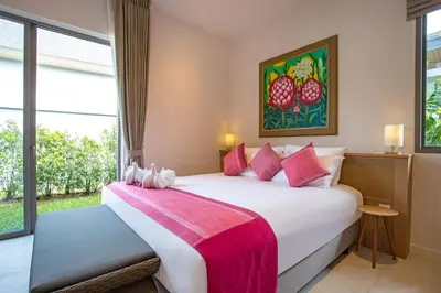 a bedroom with a large white bed and a window at Beach escape at Villa Dalaa 8 in Kamala Beach