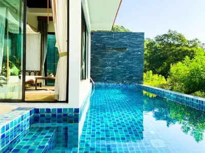 a pool with blue tile on the side of a house at Silla Villa Private Pool & Sea View in Kata Beach