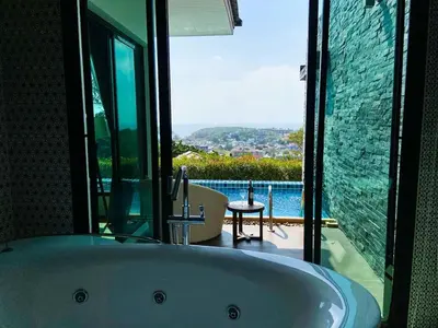 a bath tub in a bathroom with a large window at Silla Villa Private Pool & Sea View in Kata Beach