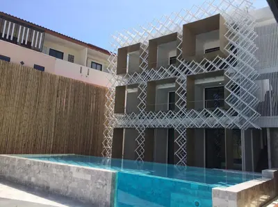 a building with a swimming pool in front of it at Yanud Residence in Phuket Town